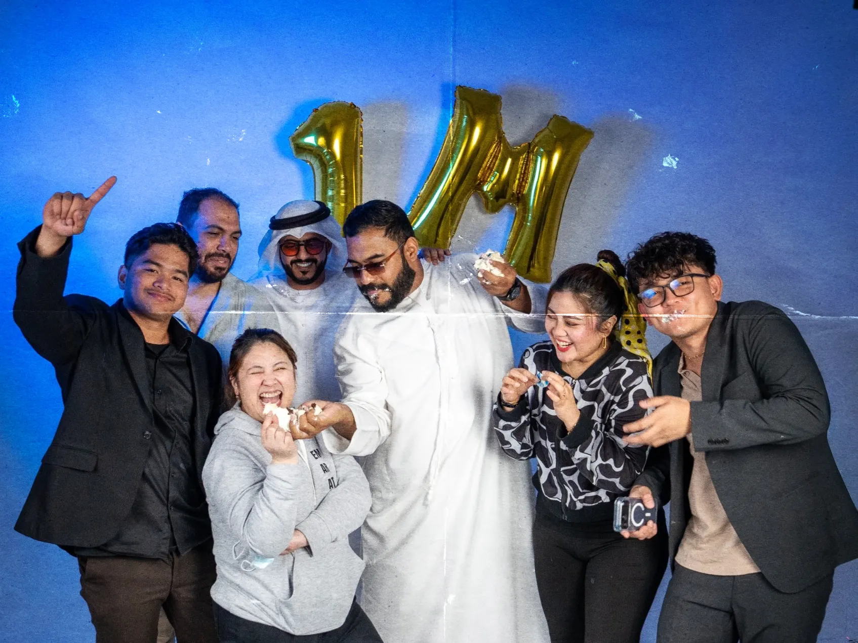 Group of people celebrating with one-million foil balloons at a studio event